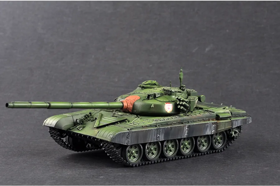 A 1/35 scale plastic model of a Russian T-72B main battle tank, painted in olive green with weathering effects and a red mantlet cover.