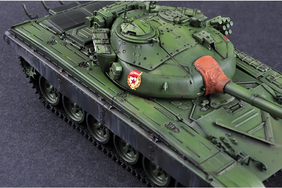 A high-angle view of a painted 1/35 scale model of a Russian T-72B tank, showing the turret, main gun, and upper hull details.