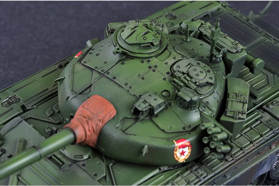 Top-down view of a 1/35 scale plastic model of a Russian T-72 tank, showing the turret, gun barrel with mantlet cover, and green camouflage paint.