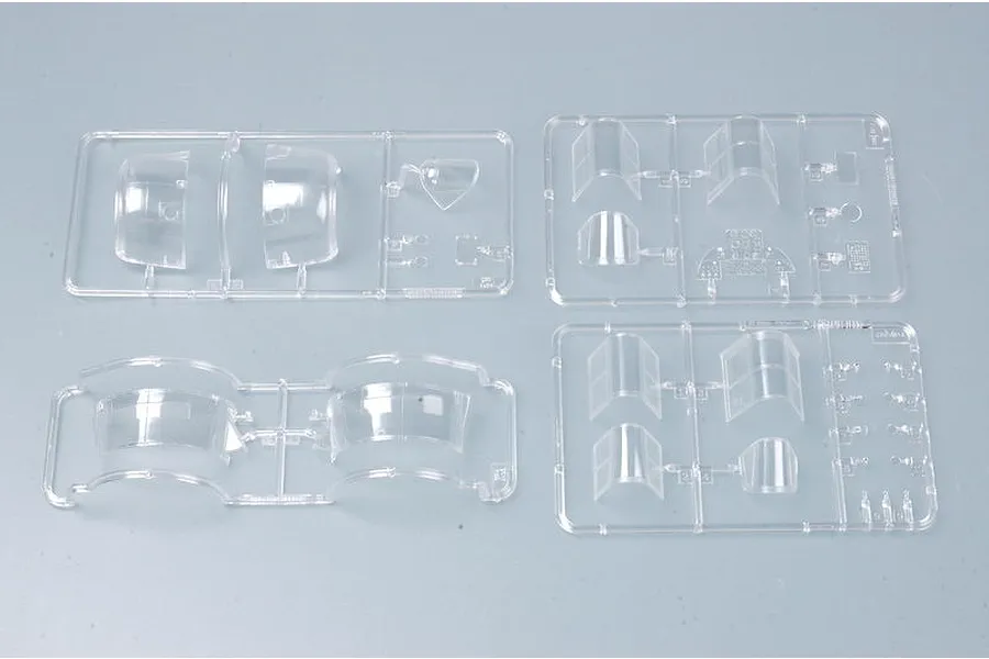 Four clear plastic model kit sprues containing aircraft canopy and cockpit parts for a Trumpeter 1/32 scale model.
