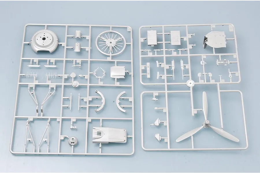 Two grey plastic model kit sprues containing aircraft parts including a propeller and engine components for a Trumpeter model kit.