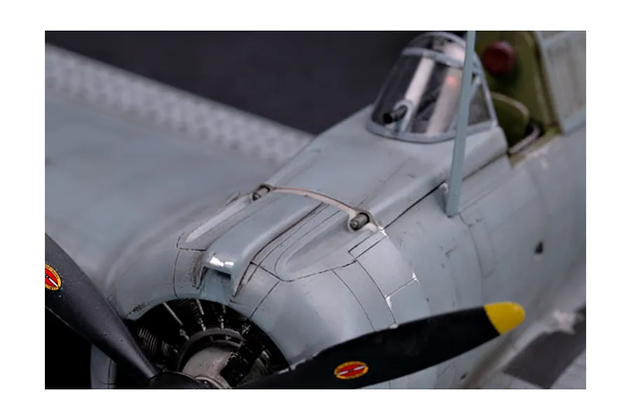 Close-up of a 1/32 scale model SBD Dauntless aircraft showing the nose, propeller, and cockpit area with weathered grey paint finish.