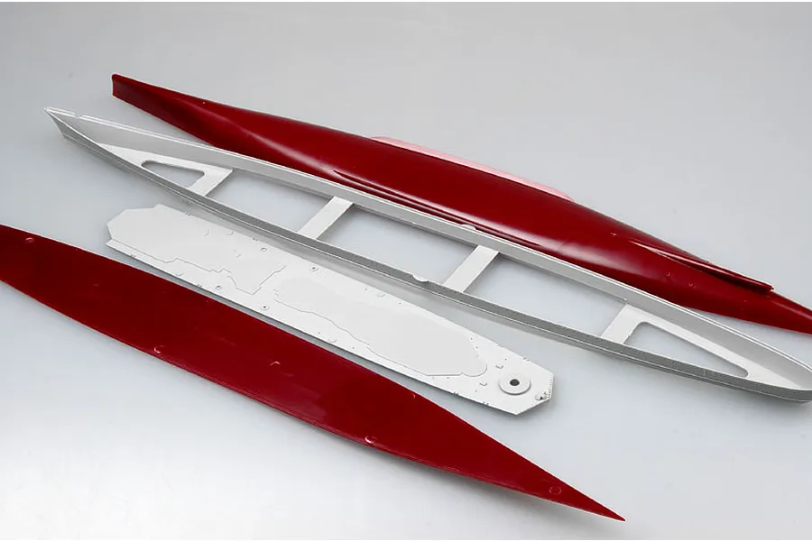 Unassembled plastic model ship hull parts including red hull sections and a white internal frame on a white background.