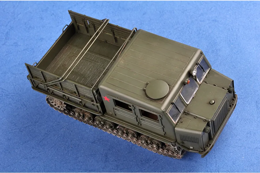 A high-angle view of an assembled and painted 1/35 scale plastic model of a Russian AT-S artillery tractor in olive green.