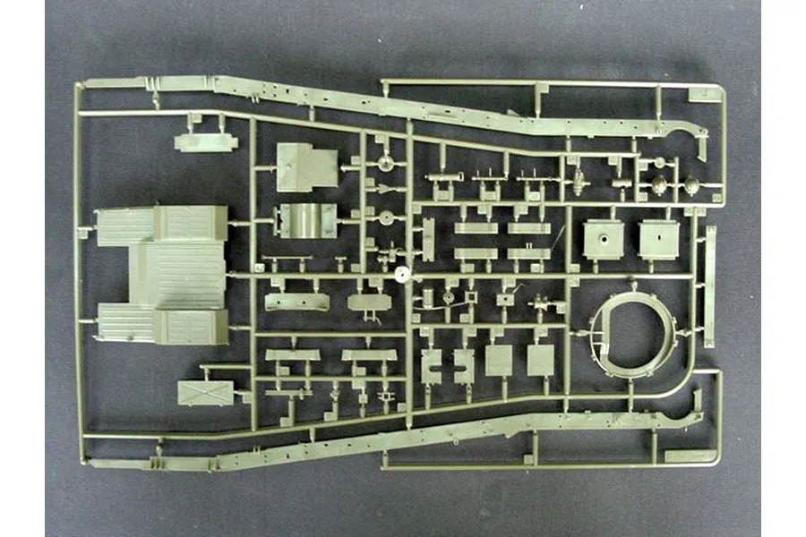 A top-down view of an olive green plastic model kit sprue containing various vehicle chassis and mechanical parts.