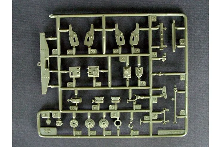 A plastic model kit sprue labeled F3 containing various small olive green parts for a military vehicle model.