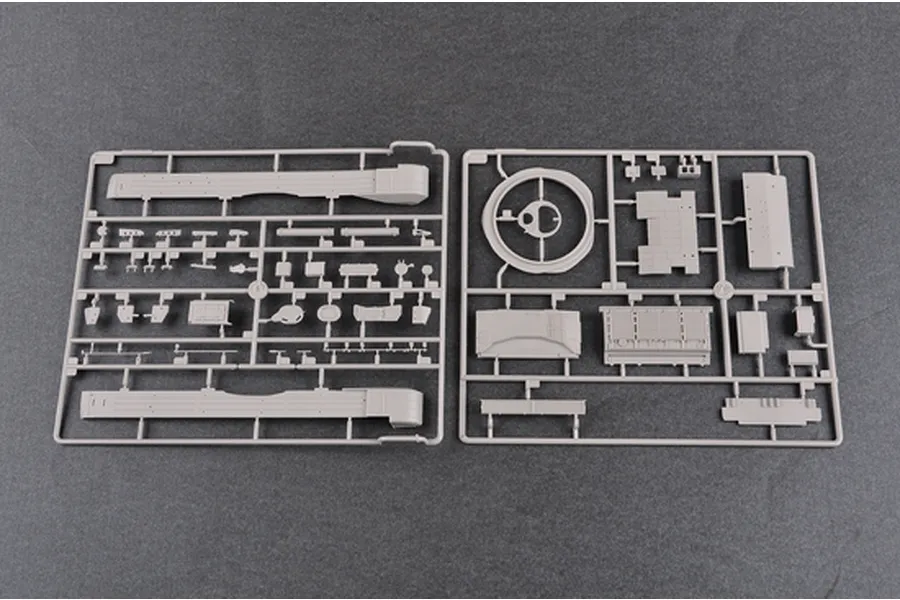 Two grey plastic model kit sprues containing various tank parts laid out on a dark grey surface.