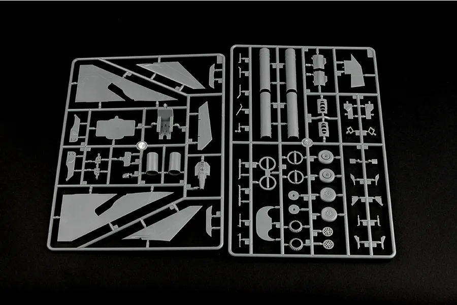 Two grey plastic model kit sprues containing various aircraft parts for a 1/48 scale model jet fighter on a black background.