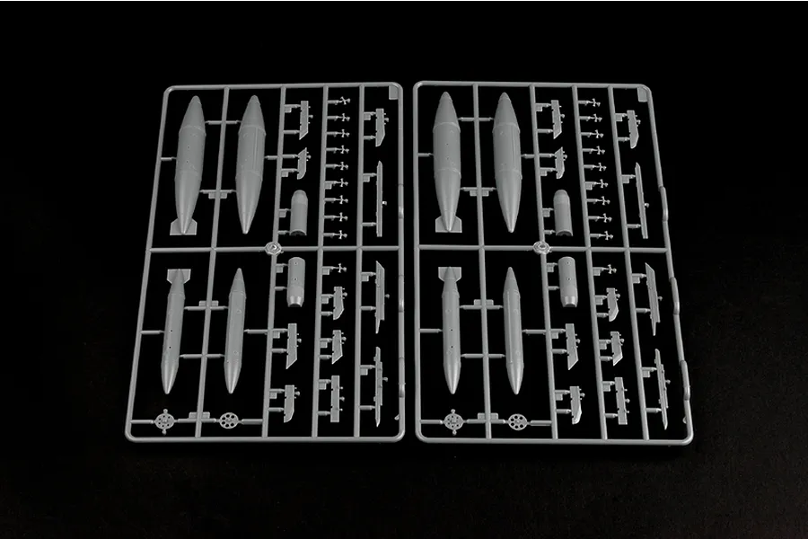 Two identical grey plastic model kit sprues containing external fuel tanks and small aircraft components on a black background.