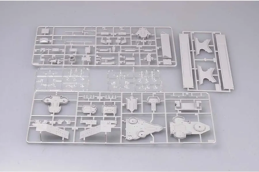 Several grey plastic model kit sprues containing various ship parts laid out on a plain grey background.