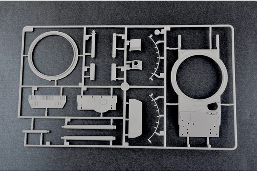A grey plastic sprue containing various tank model parts, including a turret ring and hull components, for a 1/35 scale military model kit.