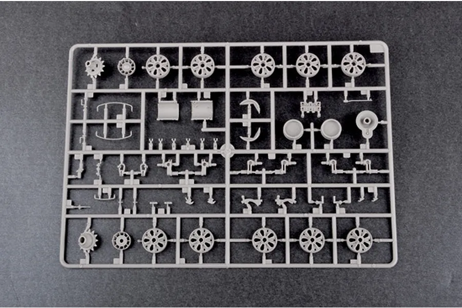 A grey plastic model kit sprue containing various tank wheel and suspension parts for a 1/35 scale model.