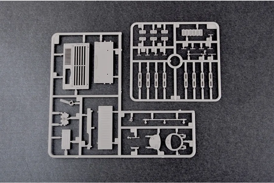 Two grey plastic model kit sprues containing various tank parts on a dark grey background.