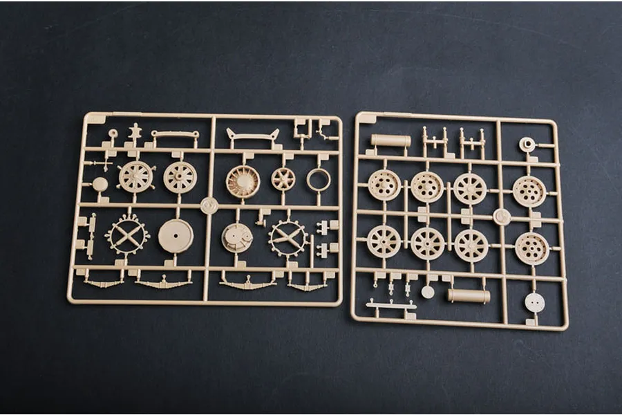 Two tan plastic model kit sprues containing various wheel and suspension parts for a 1/35 scale military vehicle model.