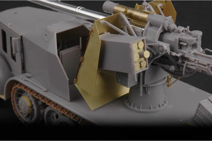 A partially assembled 1/35 scale plastic model of a German 8.8cm Flak 18 half-track, showing grey plastic parts and brass photo-etched metal details.
