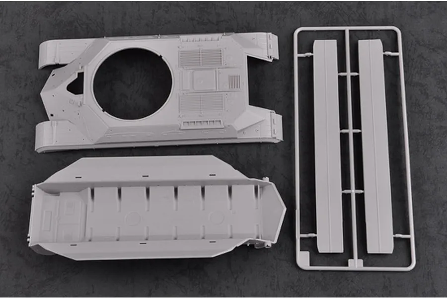 Plastic model kit parts for a Soviet T-10M tank, including the upper hull, lower hull, and a sprue with side panels on a dark textured background.