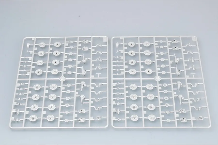 Two identical grey plastic model kit sprues containing various circular road wheels and suspension components for a 1/35 scale military vehicle.