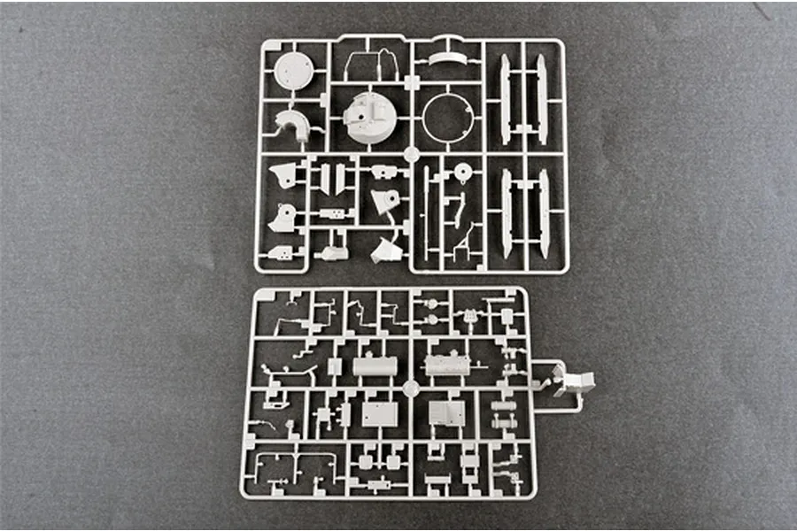 Two grey plastic model kit sprues containing various small tank parts laid out on a dark grey surface.