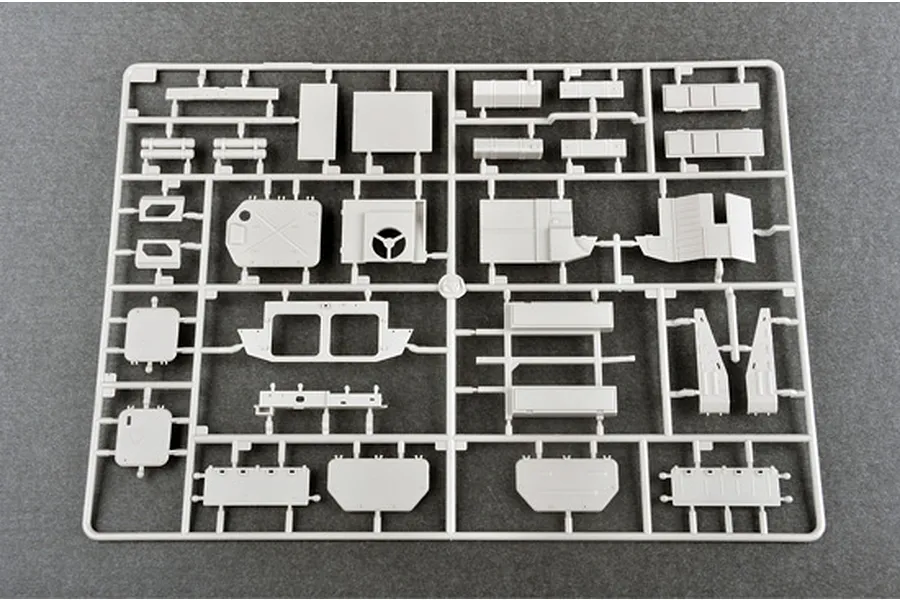 A grey plastic model kit sprue containing various flat panels and structural parts for a 1/35 scale military vehicle model.