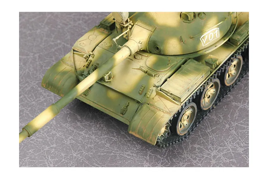 High-angle view of a painted 1/35 scale T-62 tank model with green and tan camouflage, featuring the number V01 on the turret.