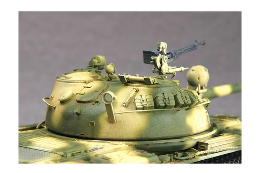 Close-up of a painted 1/35 scale T-62 tank model turret with a mounted machine gun and camouflage paint scheme.