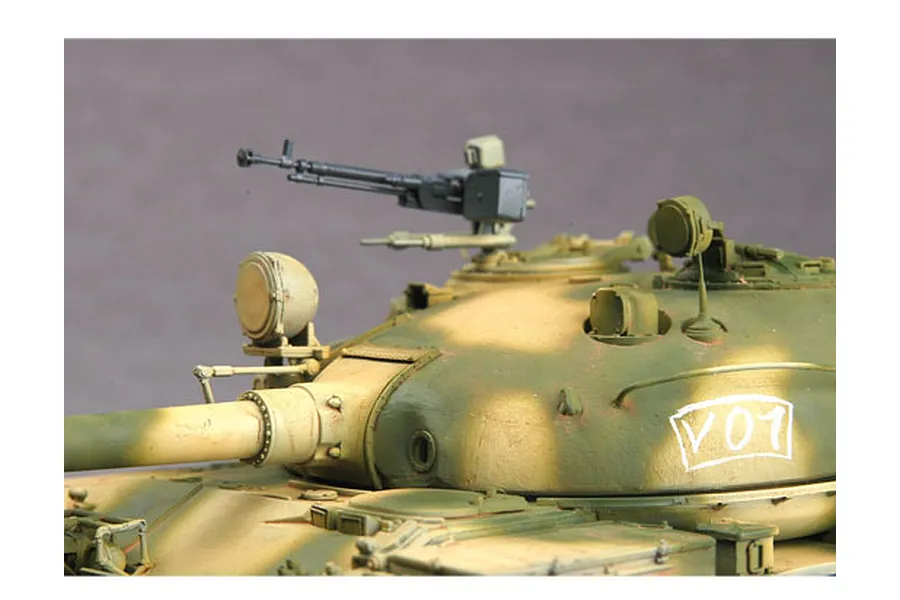 Close-up of a 1/35 scale model T-62 tank turret with camouflage paint and a machine gun mounted on top.