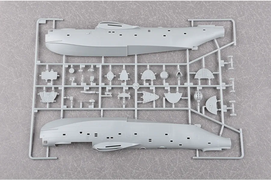 A grey plastic sprue from a Trumpeter 1/72 scale Be-6 Madge model kit, showing the two main fuselage halves and various smaller interior components.