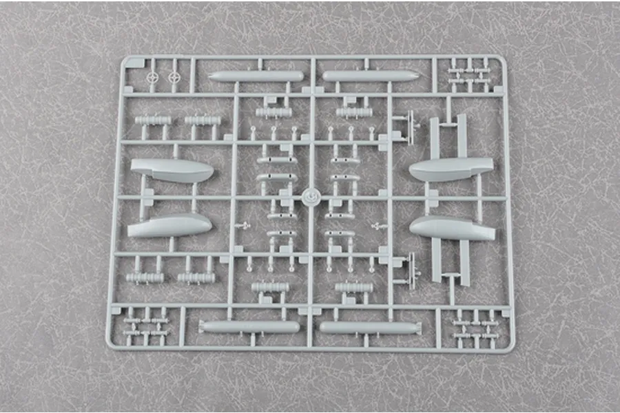 A grey plastic sprue containing various model aircraft parts, including external fuel tanks and small components, for a Trumpeter 1/72 scale model kit.