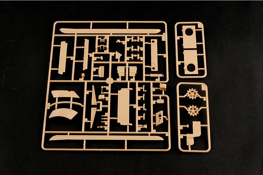 Tan plastic model kit sprue containing various tank parts on a black background.