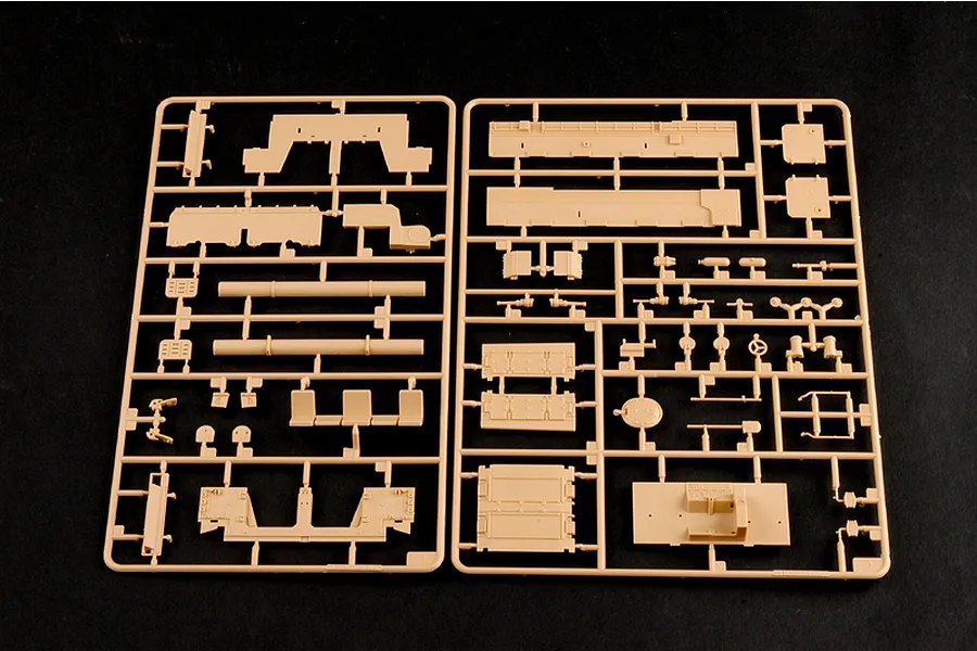 Two tan plastic model kit sprues containing various vehicle parts for a 1/35 scale military model kit on a black background.