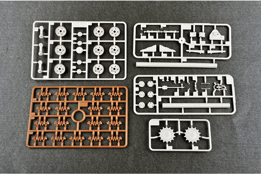 Four plastic model kit sprues for a 1/35 scale tank, including grey and brown parts on a dark grey surface.