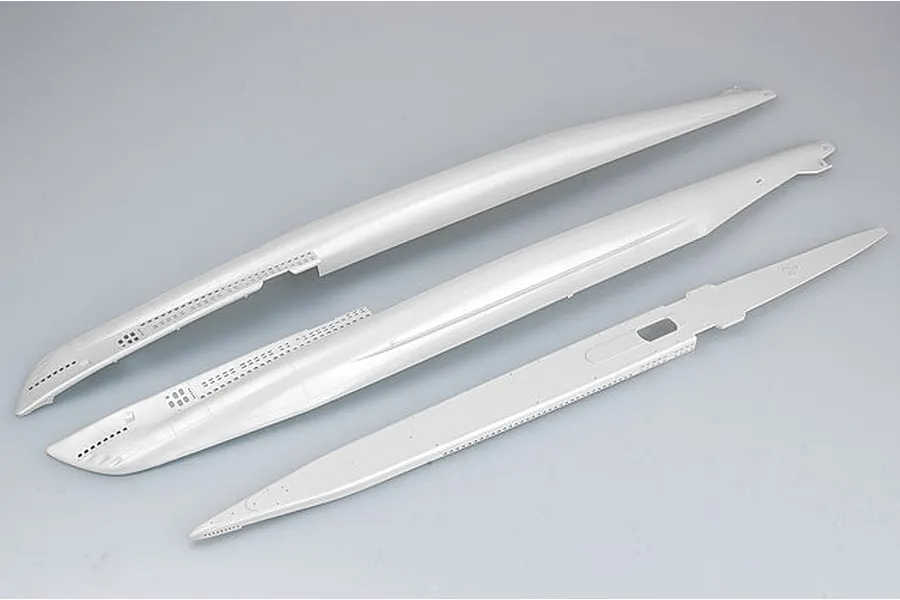 Three unpainted grey plastic model submarine hull parts laid out on a plain background.