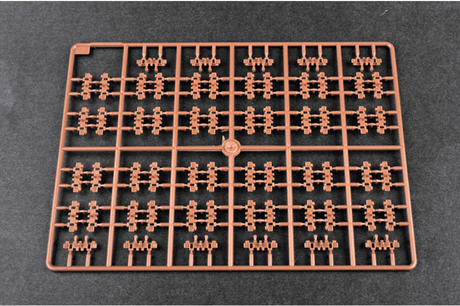A brown plastic sprue containing multiple small tank track link segments for a 1/35 scale model kit.