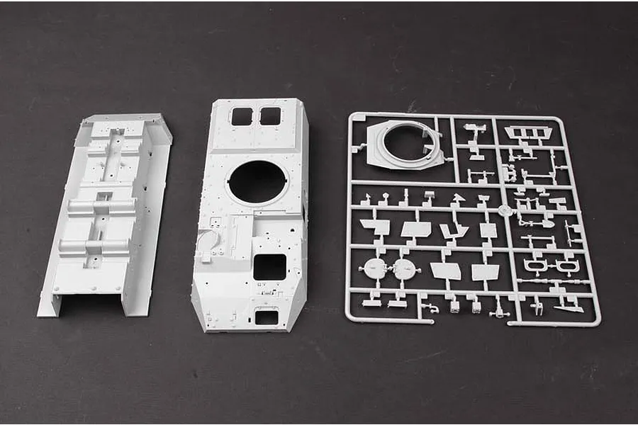 Unassembled grey plastic model kit parts for a 1/35 scale LAV-III armoured vehicle, including hull sections and a sprue of smaller components.