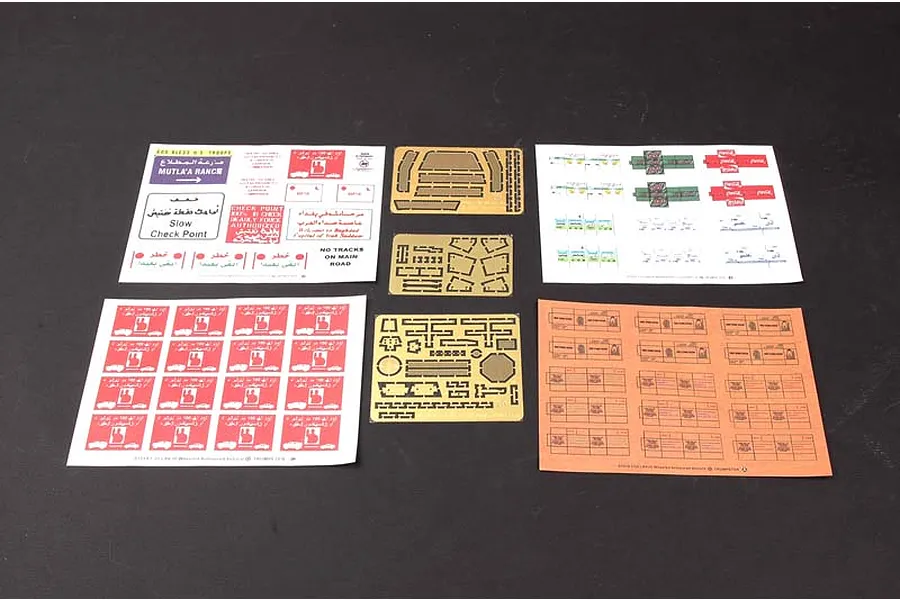 A collection of decal sheets and photo-etched metal parts for a 1/35 scale model kit, laid out on a dark surface.