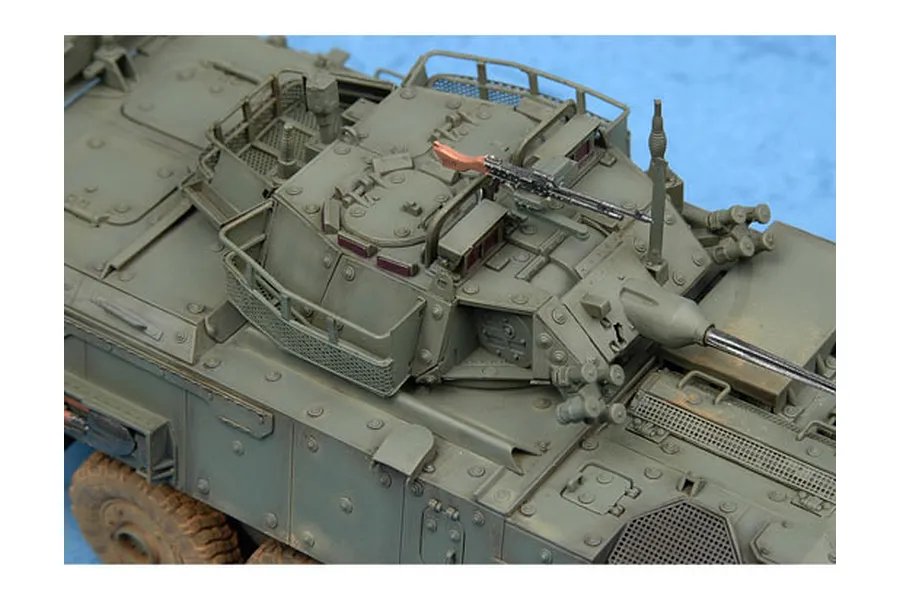 A high-angle close-up of a 1/35 scale plastic model of a LAV-III armoured vehicle, showing the turret, hatch, and mounted machine gun.