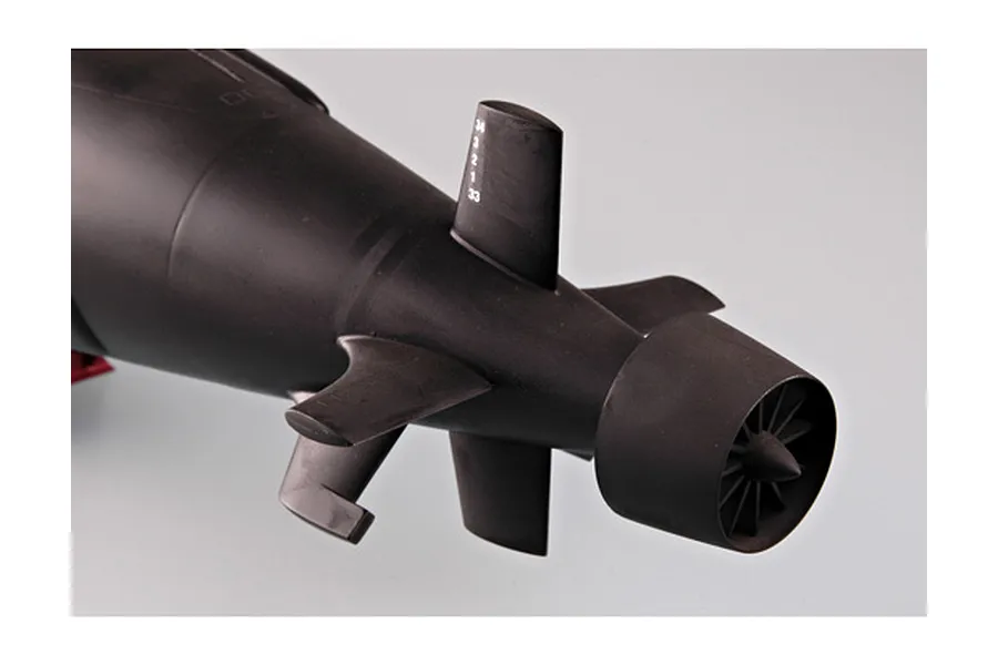 Close-up of the rear section of a black plastic model submarine showing the tail fins, rudder, and shrouded propeller.