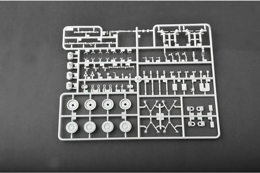 A grey plastic sprue containing various small parts for a 1/35 scale model tank kit, including wheels and suspension components.