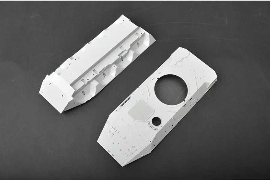 Two unpainted white plastic model tank hull components from a Trumpeter 1/35 scale kit, viewed from above against a dark grey background.