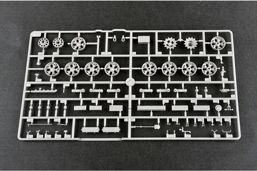 A grey plastic sprue containing various model tank parts, including road wheels, sprockets, and suspension components for a 1/35 scale model kit.