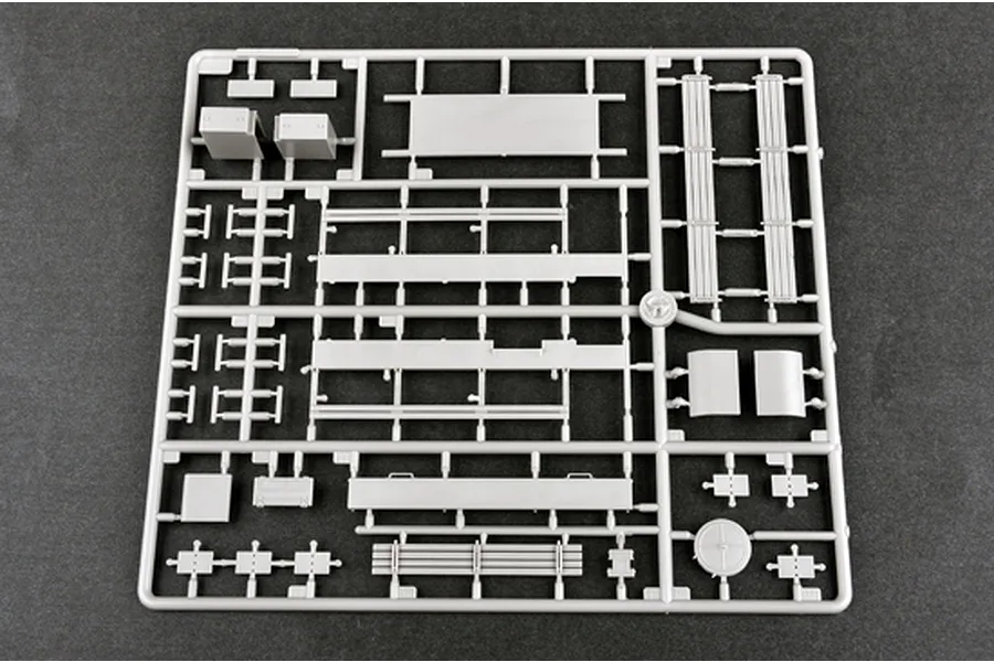 A grey plastic sprue containing various model parts for the Trumpeter 1/35 Russian AT-T Artillery Prime Mover kit, set against a dark grey background.