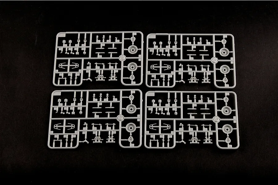 Four identical grey plastic model kit sprues arranged in a grid on a black background.