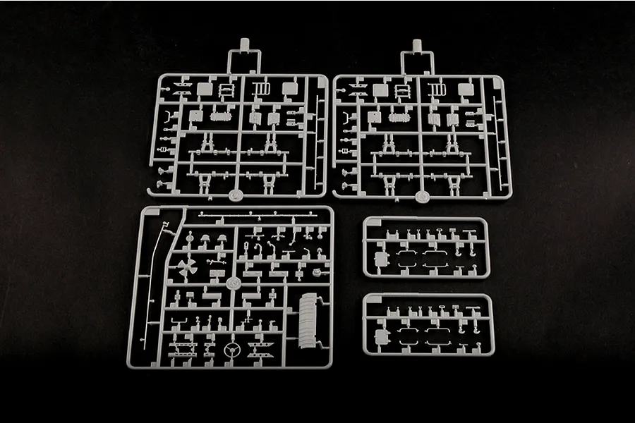 Five grey plastic model kit sprues containing various small parts for a 1/35 scale military vehicle model, laid out on a black background.