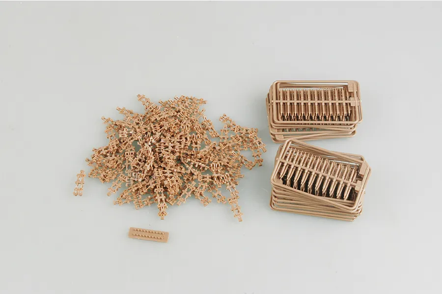 Tan plastic model tank track links and sprues for a 1/35 scale military model kit.