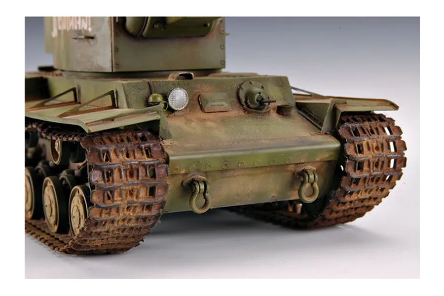 A close-up view of the front of a 1/35 scale Russian KV-2 tank model, featuring weathered green paint, rusted tracks, and detailed hull components.
