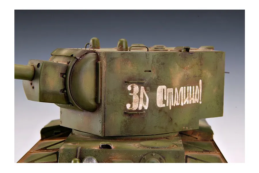 A close-up view of a weathered 1/35 scale Russian KV-2 tank model, featuring a large turret with Cyrillic text painted on the side.