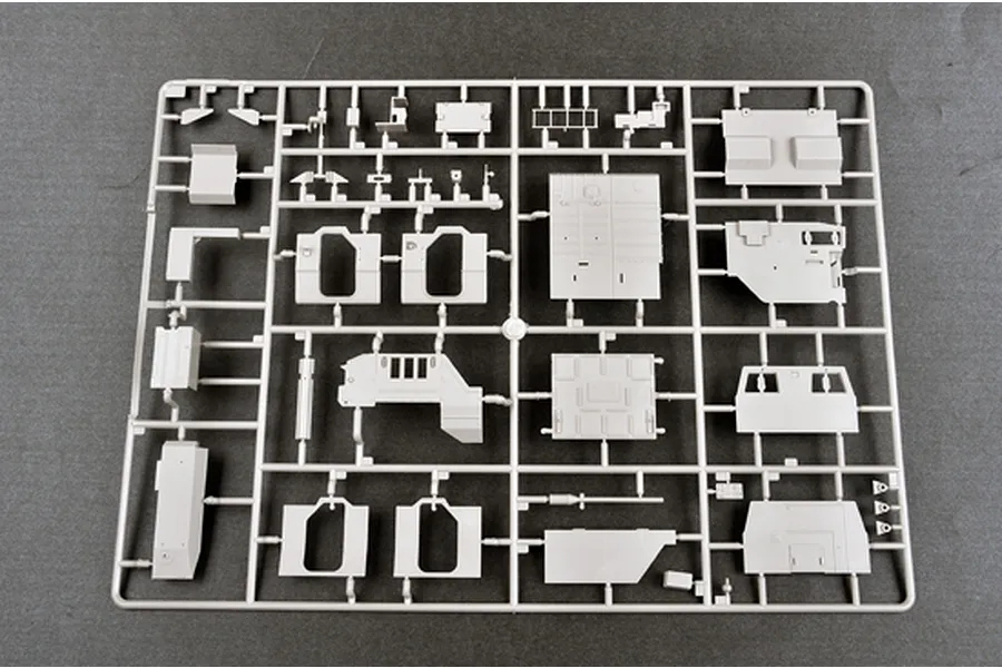 A grey plastic model kit sprue containing various vehicle body panels and components for a 1/35 scale military model kit.