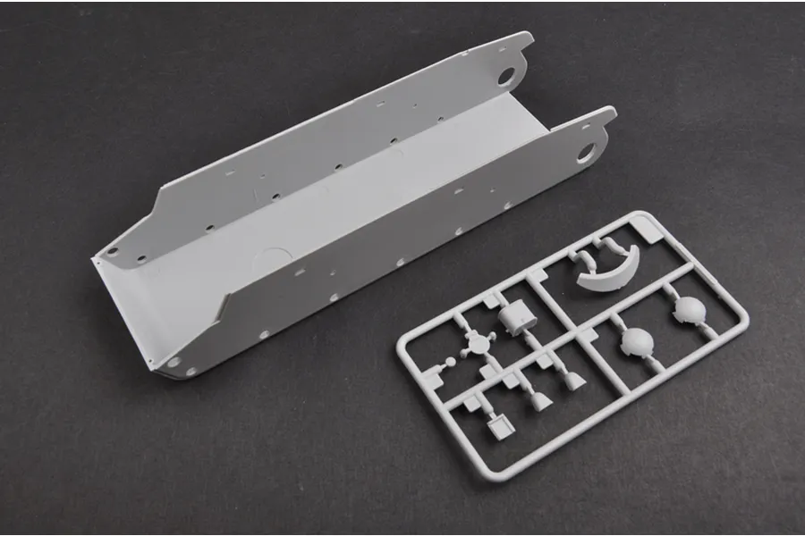 A grey plastic tank hull piece and a small sprue of model parts for a 1/35 scale Soviet SU-152 model kit.