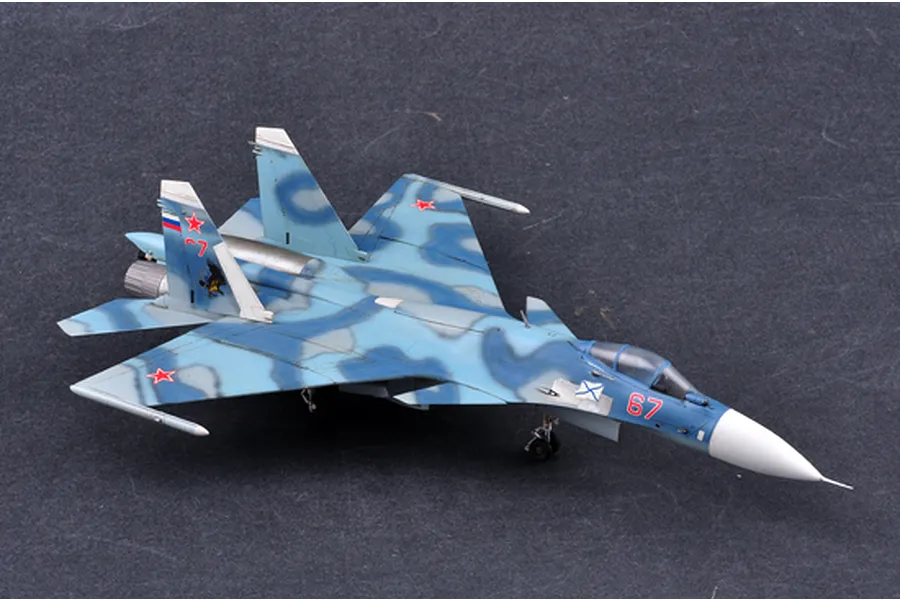 A completed 1/72 scale plastic model of a Russian Su-33 Flanker D fighter jet, featuring a blue camouflage paint scheme and red number 67 markings.