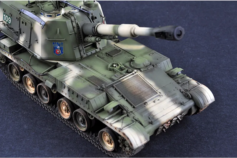 A high-angle view of a 1/35 scale PLZ-83A self-propelled gun model kit, painted in a green camouflage scheme with weathered details.